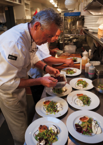 Douglas Dale '76 plating salads in the Wolfdale's kitchen. Photograph © Shea Evans