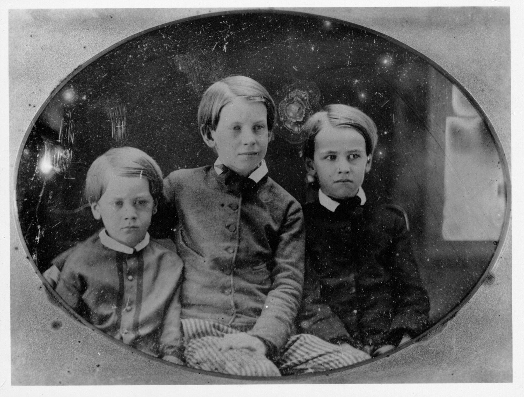 A black and white photograph. The sons of Horace and Mary Mann, c1855. Left to Right, Benjamin Pickman Mann, Horace Mann Jr., George Combe Mann.