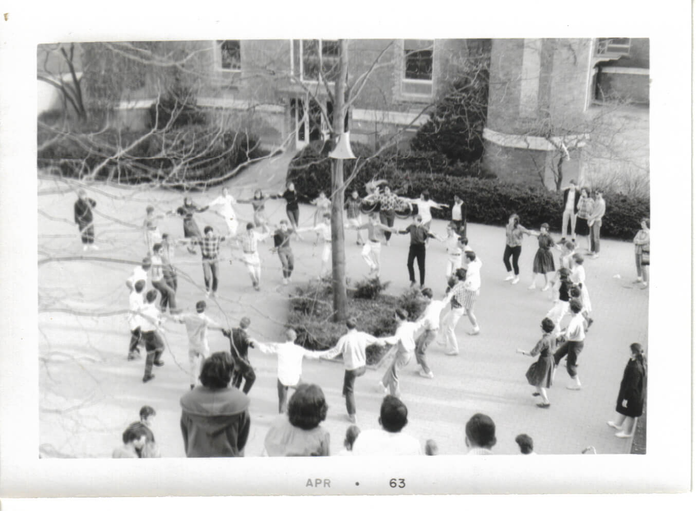 Antioch students dancing hand in hand in huge circles in red square back in the 1960s